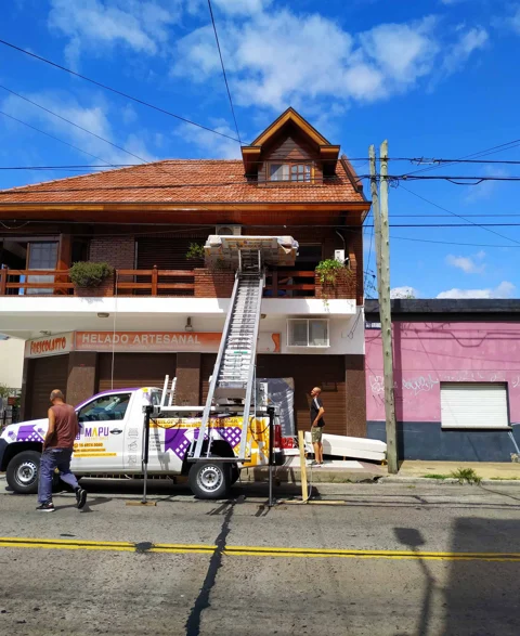 Equipo de elevación en operación frente a una vivienda